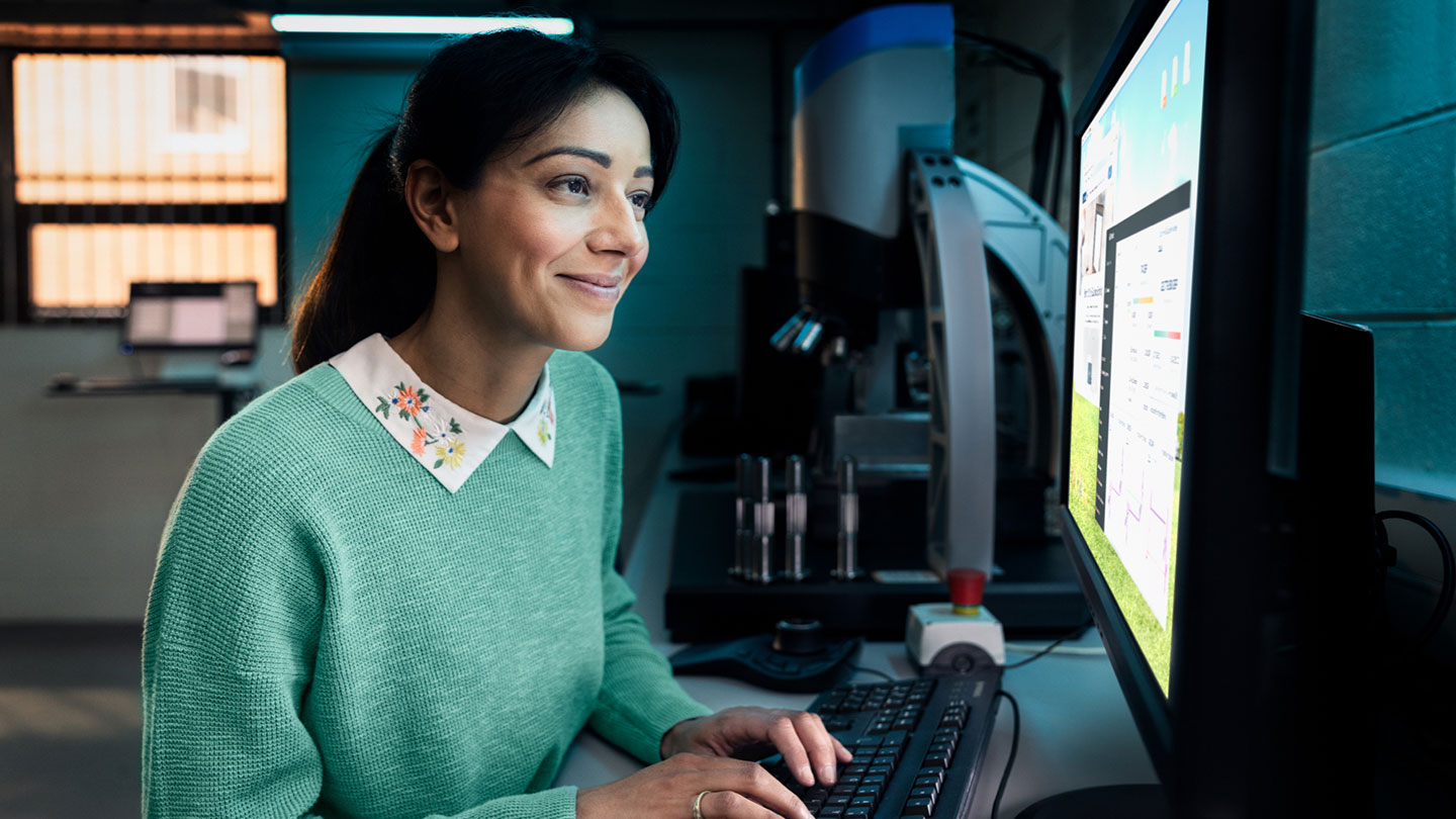 Happy woman in lab using computer