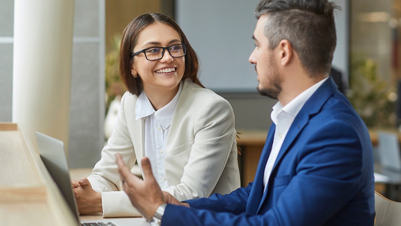 Woman and Man sitting at a desk with laptop