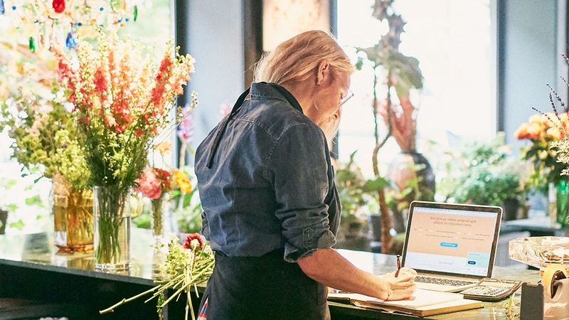 Woman working on laptop in florist shop
