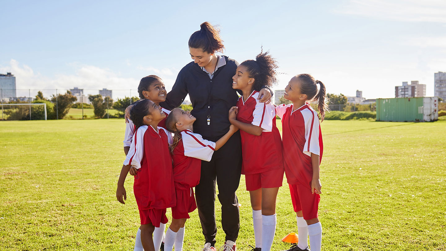 Female football coach with young girls