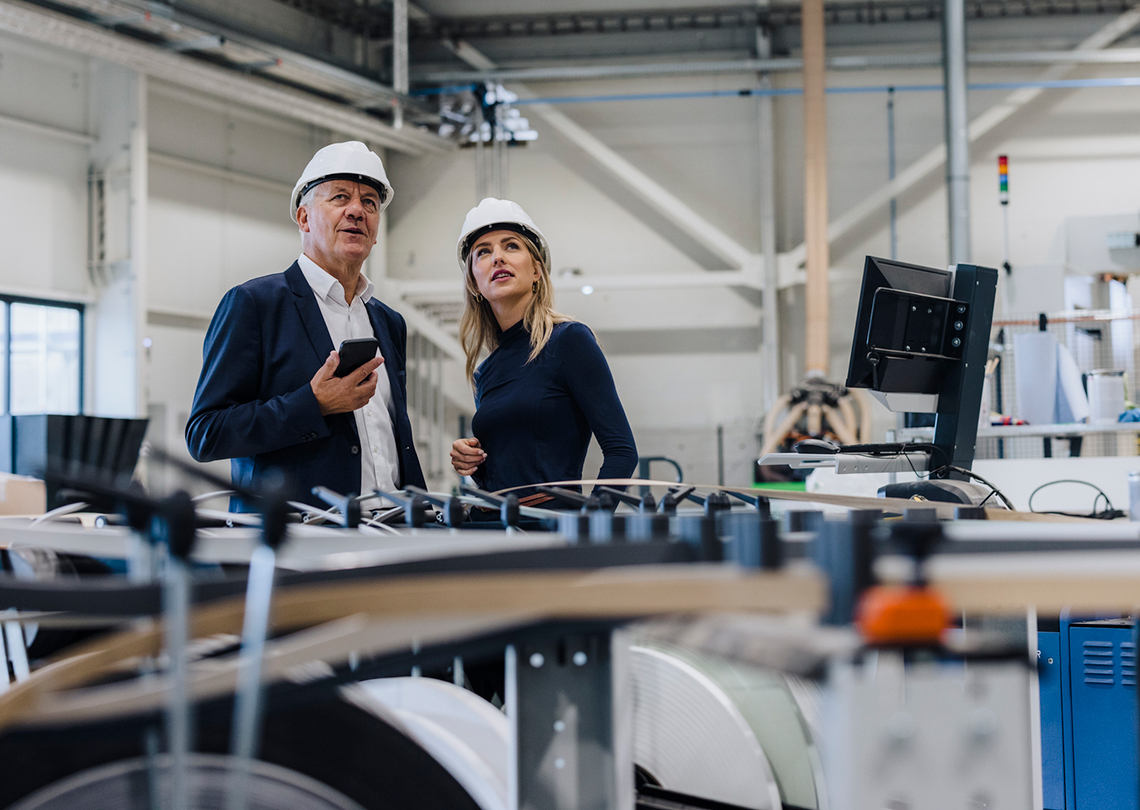 Man and Woman with hardhats in a manufacturing facility