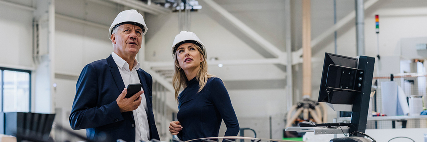 Man and Woman with hardhats in a manufacturing facility