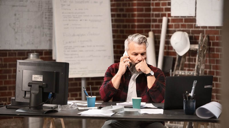 Man at desk using mobile phone