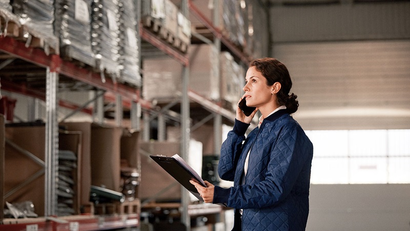Woman in warehouse with clip pad Woman in warehouse with clip pad