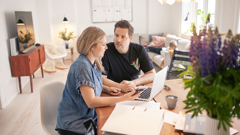 Male and female at dining table with laptop Male and female at dining table with laptop