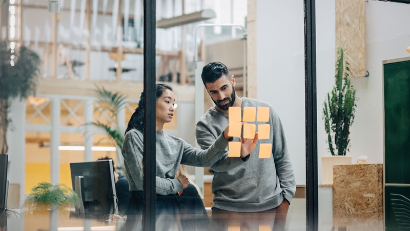 Man and woman using post-it notes
