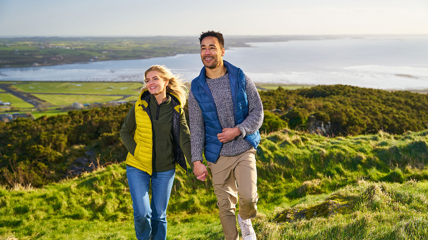 Couple walking at Scrabbo tower with Strangford lough in background Couple walking at Scrabo tower with Strangford lough in background
