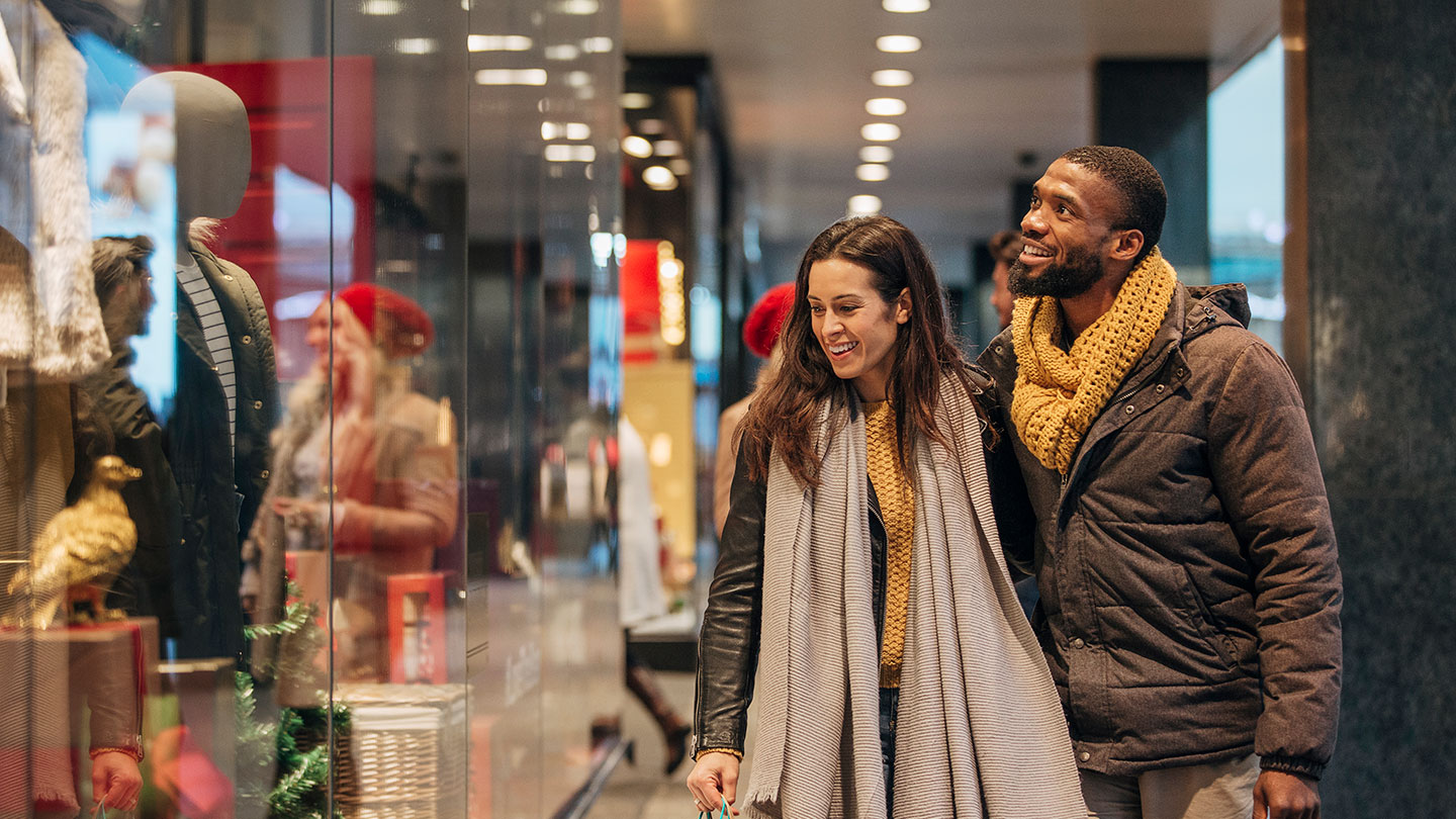 Happy couple looking at shop windows