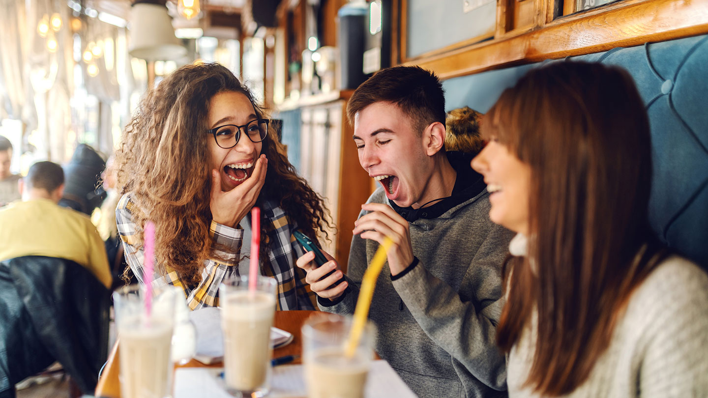 Teenagers Teenagers sitting in cafe enjoying milkshakes