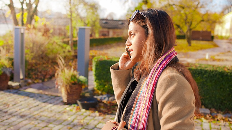 Woman wearing scarf using mobile phone Woman wearing scarf using mobile phone