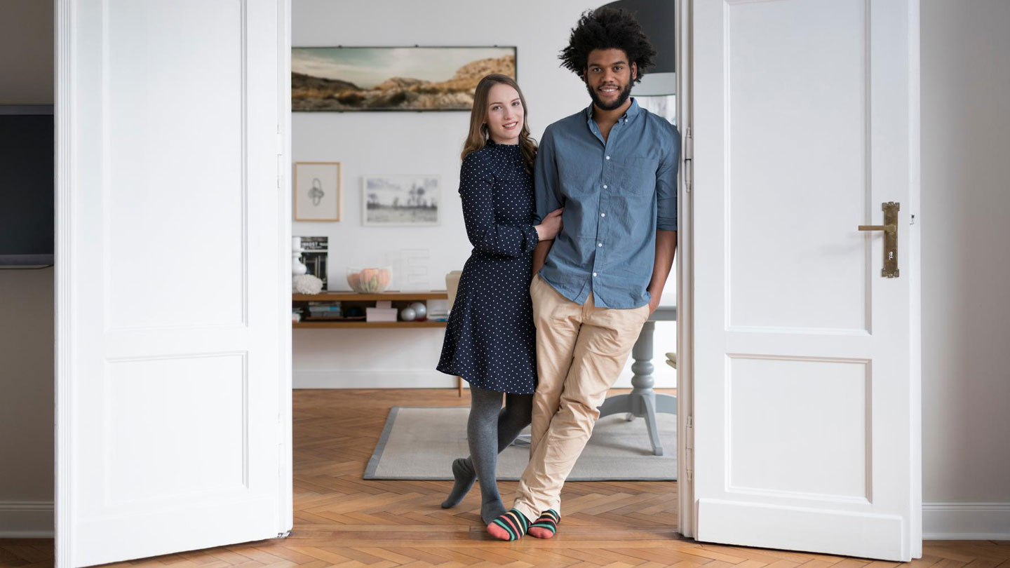 Mixed race couple standing at open internal door