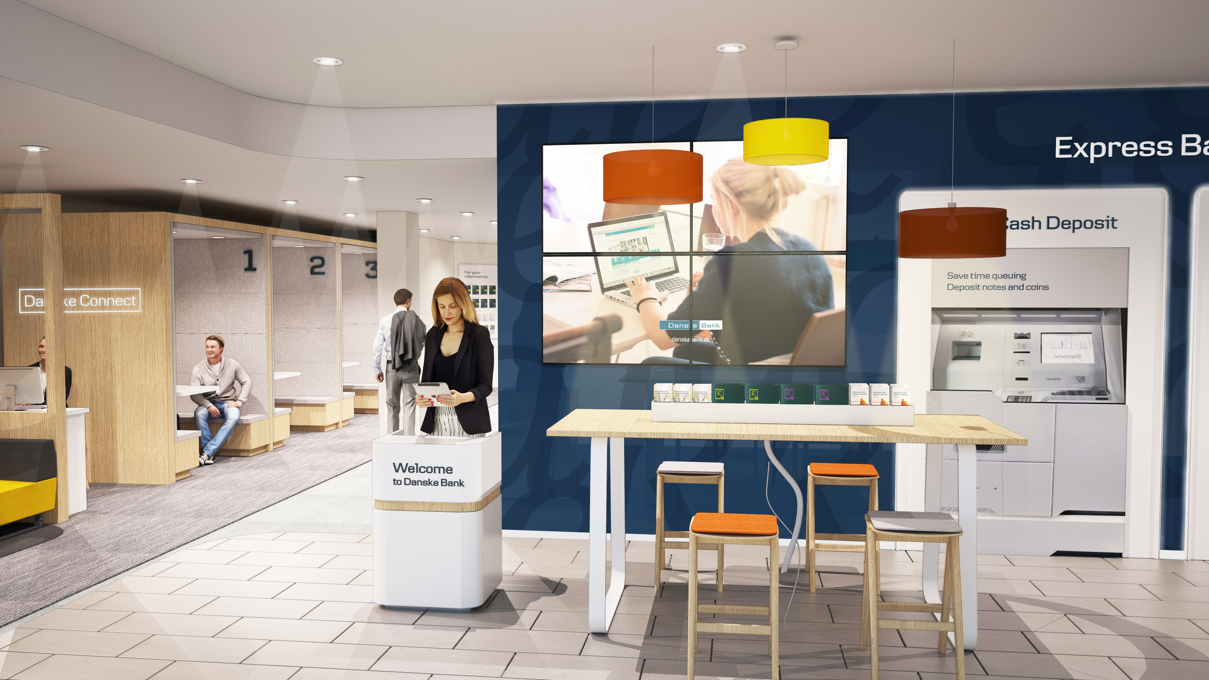 Image shows a mocked up version of the welcome hall of the new Bloomfield Danske Bank branch. To the left are Danske Connect pods, a light yellow. To the righ is a navy wall with a big TV, a high table and stools and some express deposit machines for lodging money.