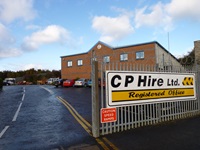 Photo taken outside a CP Hire Ltd. office building. Shows a road in, cars parked in front of an office and a large sign that says 'CP Hire Ltd'.
