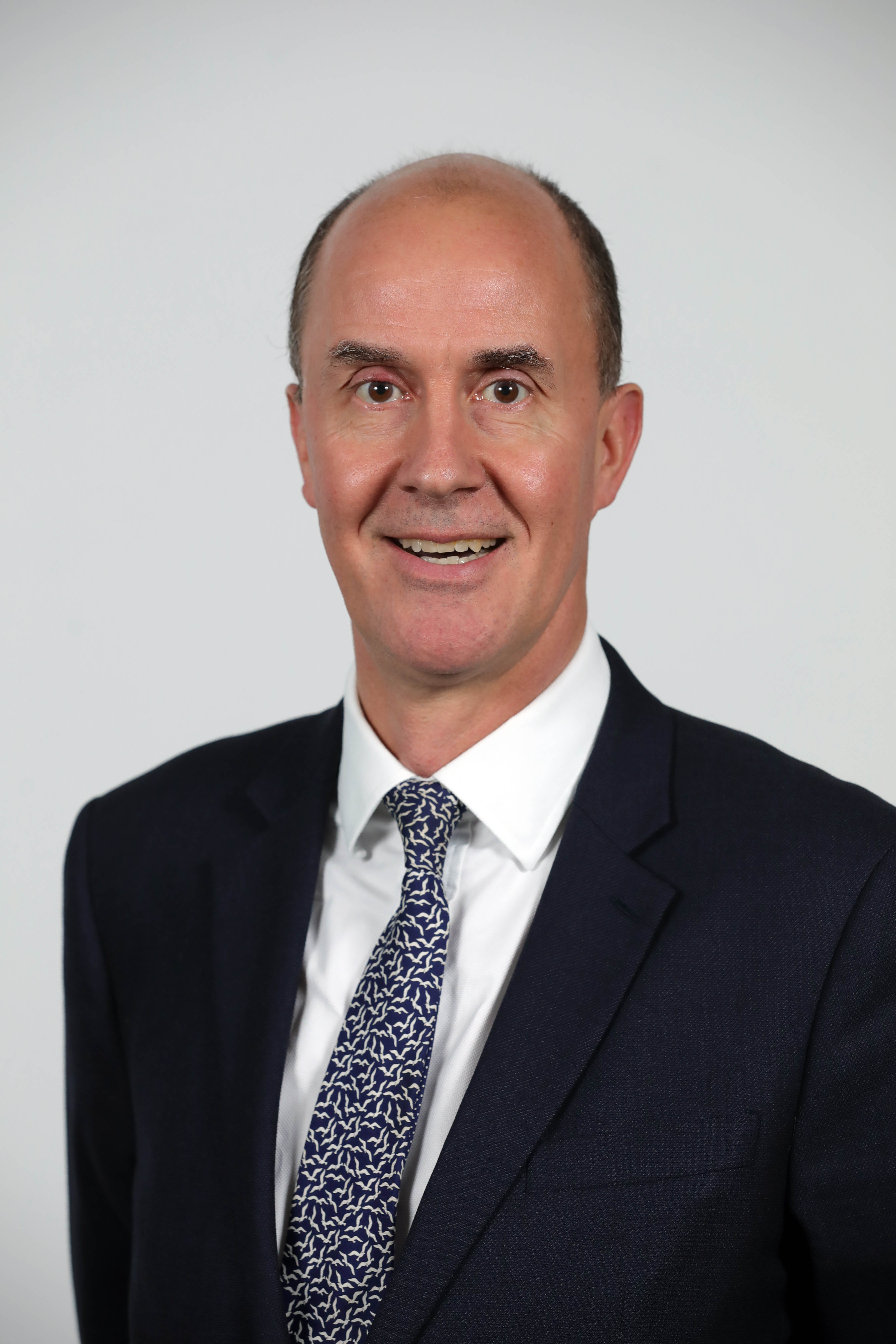 Headshot of a man in a suit.