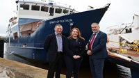 Rathlin Ferry marks successful first year of operations since takeover by new owners Three people pictured at a harbour. Behind them is a ferry boat called 'Spirit of Rathlin'