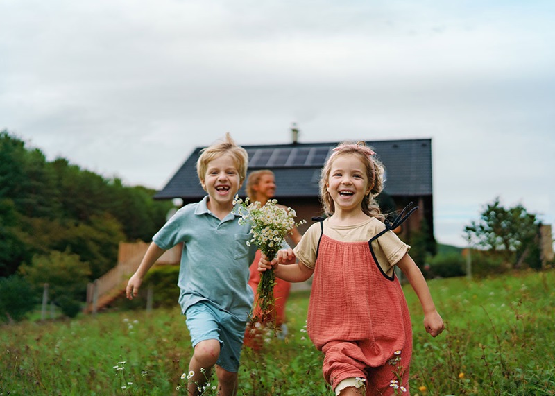 Boy and girl running in field with flowers