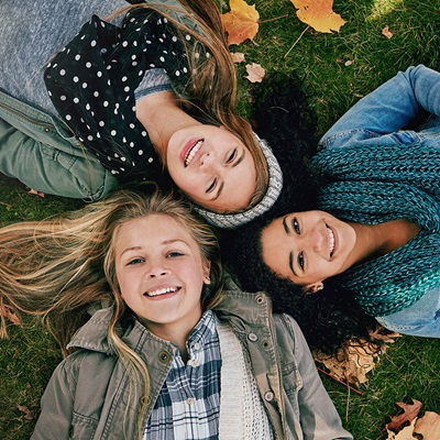 Young ladies lying on grass smiling