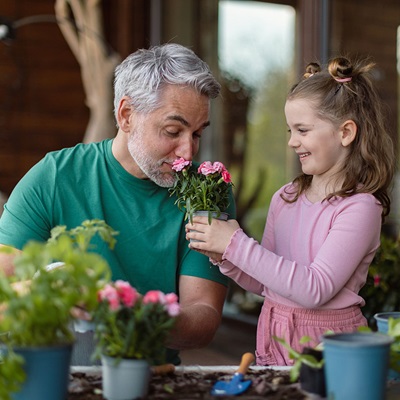 Young girl and adult male smelling flowers