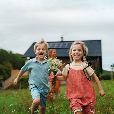 Boy and girl running in field with flowers