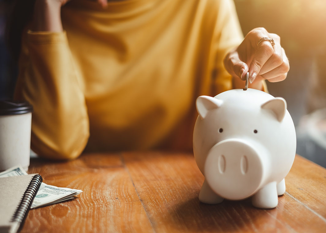 Woman putting coins in piggybank
