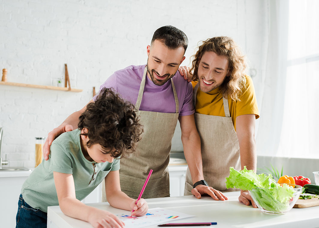 Two male adults with child colouring in