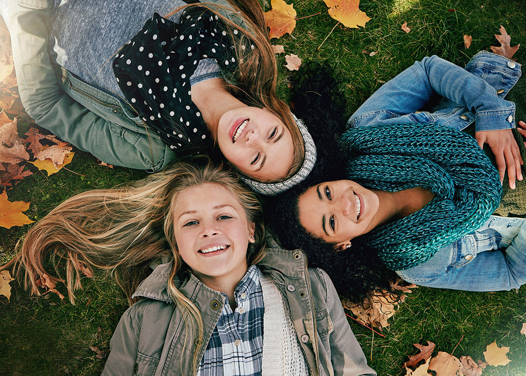 young ladies lying on grass